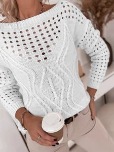 Détails de la maille du pull blanc à manches longues avec motifs ajourés et torsades