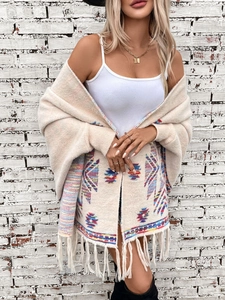 Detail of bohemian knit cardigan featuring geometric patterns and long tassel fringe hem
