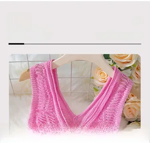 Detailed view of pink knitted crop top neckline featuring intricate hollow crochet patterns