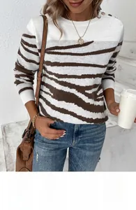 Detail of metal shoulder buttons on a zebra print knit sweater with contrasting stripes