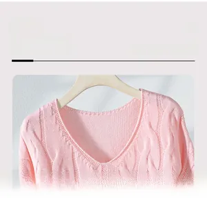 Close-up of pink cable knit V-neck sweater showing texture and neckline detail