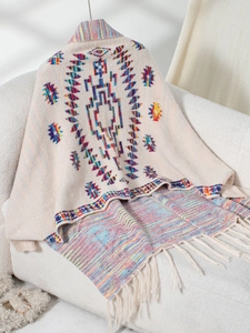Close-up of geometric jacquard pattern and fringe detail on beige ethnic knit shawl
