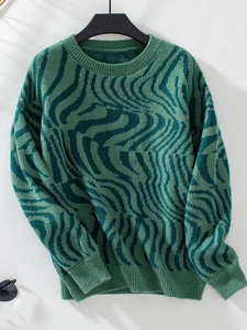 Detailed close-up of green zebra pattern knit sweater with ribbed cuffs and round neck