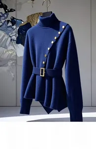 Detail of navy knit sweater featuring asymmetric hem and elegant gold button accents