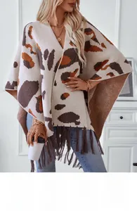 Detailed close-up of knit texture and leopard pattern with tassels on women's poncho
