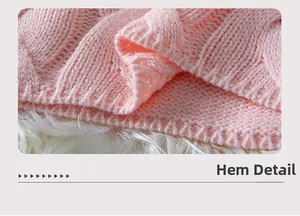 Macro shot of the knitted hem showing cable-knit texture and ribbed cuffs in soft pink
