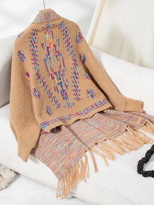 Macro detail of Aztec geometric knit cardigan with ethnic patterns and fringe tassels