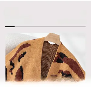 Detailed neckline view of a knit leopard print tassel poncho cape for winter