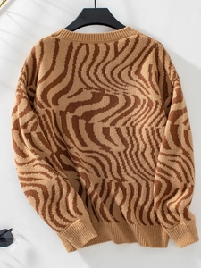Detailed view of camel and brown zebra wavy knit sweater with ribbed cuffs and hem