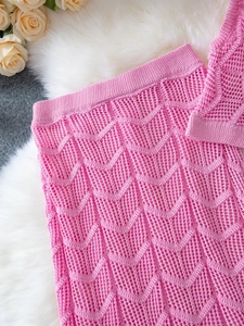 Detail of pink crochet knit skirt featuring wave hollow-out pattern and elastic waistband