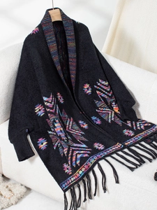 Detail of bohemian knit cardigan with colorful geometric patterns and long black fringes