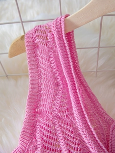 Macro shot of hot pink hollow knit fabric texture on a wooden hanger with clean background
