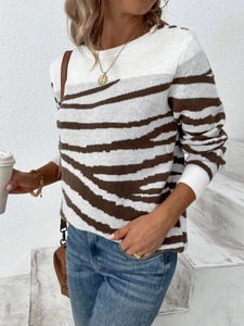 Detail of shoulder gold buttons on zebra stripe knit sweater with ribbed neckline