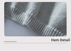 Detail of the ribbed hemline on a casual grey knitted sweater with fine stitch texture