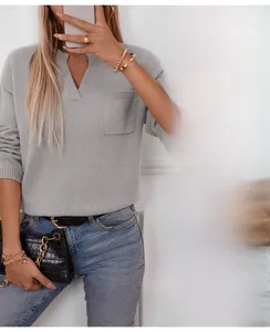 Detailed V-neck design of women's knit sweater featuring decorative chest pocket