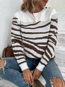 Detail of knit sweater with zebra pattern and gold shoulder buttons on crewneck