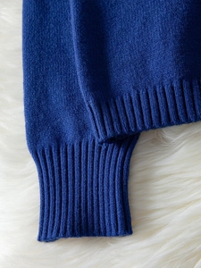 Detailed close-up of high-quality navy blue knit fabric with ribbed cuff textures