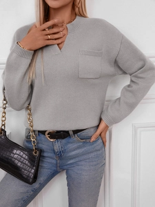 Close-up of light grey knit sweater featuring a notch V-neckline and chest pocket detail