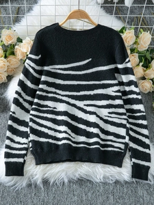 Close-up of zebra pattern knit sweater with ribbed cuffs and round neck detail