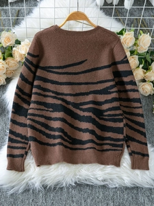 Close-up of Zebra pattern knit texture and shoulder buttons on long sleeve sweater