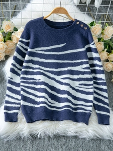 Detailed view of navy zebra print sweater with three gold buttons on the shoulder