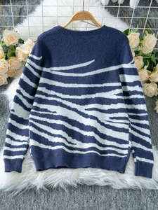 Close-up of zebra pattern knit sweater with navy contrast and ribbed cuffs