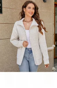 Detail of knit pattern and zipper on cream cable-knit cardigan with front patch pockets