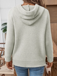 Dettaglio del cappuccio morbido e della trama a coste su questo maglione verde salvia