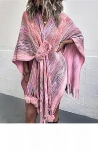 Details von Stricktextur mit rosa Bommeln und Boho-Quasten auf einem Space-Dyed-Poncho