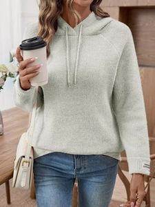 Dettaglio felpa con cappuccio in maglia verde menta con trama a nido d'ape ed etichetta