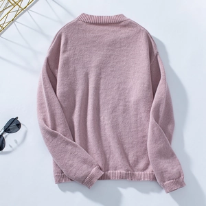 Flat lay of pink knitted sweater back view showing ribbed cuffs and neckline details