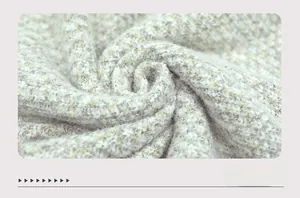 Macro view of soft white and yellow knit fabric texture on cozy cardigan