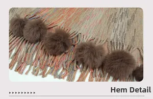 Detailansicht des bunten Strickschal-Saums mit Fransen und braunen Pelzbommeln