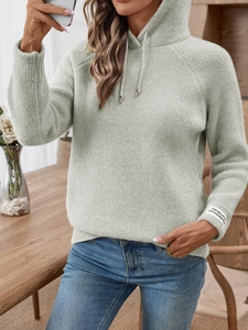 Dettaglio maglione con cappuccio in maglia a nido d'ape verde chiaro con etichetta