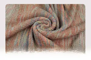 Detailaufnahme des bunten Strickschal-Stoffs mit Wellenstruktur und Metallgarn-Effekt