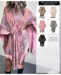 Detail eines Strickponchos mit farbigen Pompons und Fransen in fünf verschiedenen Farben