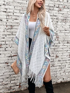 White knit bohemian poncho cape with colorful ethnic patterns and long fringe tassels