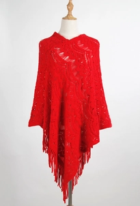 Close-up of red crochet knit poncho featuring hollow-out patterns and long fringe tassels
