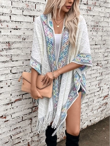 Ethnic knit poncho cardigan with geometric jacquard patterns and tassel hem on white backdrop