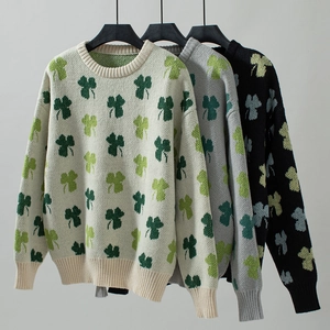 Détails des bords-côtes sur les pulls en maille oversize avec jacquard de trèfle à quatre feuilles