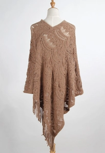 Detailed knit pattern and long fringes on a brown hollow-out crochet poncho shawl