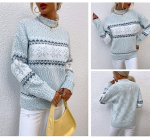 Detail view of light blue Nordic knit sweater with snowflake patterns and high collar