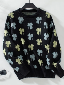 Détail du motif trèfle sur pull en maille ample avec poignets et col en tricot côtelé