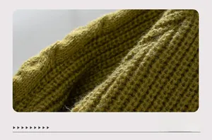 Nahaufnahme von olivgrünem Strickstoff mit Zopfmuster und Wabenstruktur-Details
