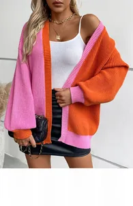 Detail of color-block knit cardigan in pink and orange with textured chunky knit fabric