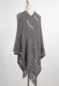 Detailed knit texture of grey crochet poncho featuring bohemian hollow patterns and tassels