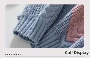 Detail of color-block cable knit sweater showing blue and pink ribbed cuff texture
