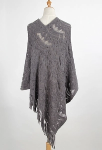 Detail of grey hollow-out knit shawl featuring intricate floral patterns and fringe hem