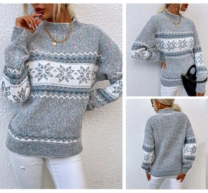 Close-up of snowflake knit patterns and texture on blue-gray winter sweater