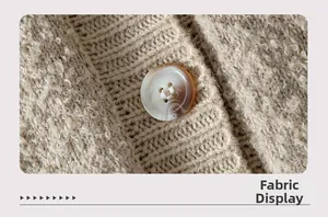 Macro shot of fluffy oatmeal knit fabric and vintage amber button detail on cardigan